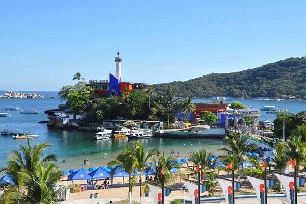“Shaded shoreline at Caletilla Beach in Acapulco—gentle waves, palm-lined walkways, and nostalgic charm for family-friendly coastal escapes.”