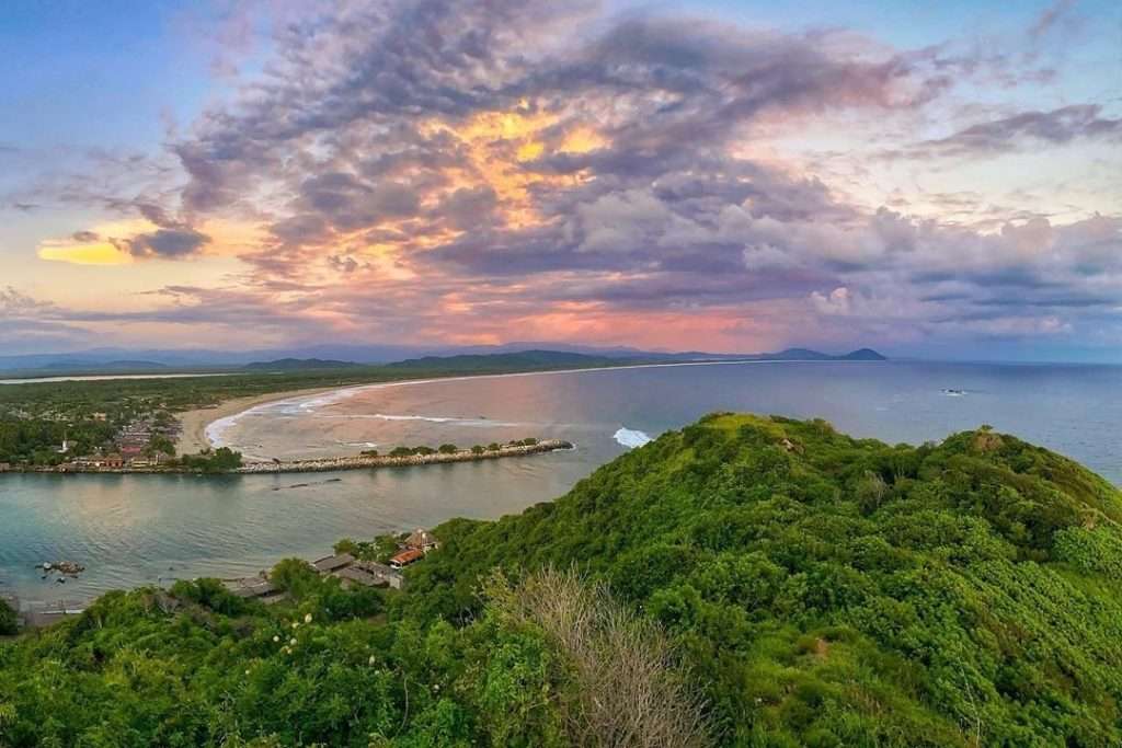 Bioluminescent lagoon and mangrove sanctuary at Lagunas de Chacahua with Afro-Mexican cultural elements.