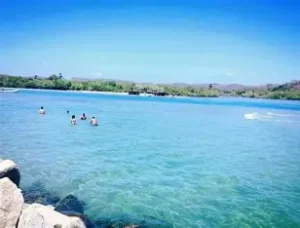 Expansive lagoon and beach at Playa Corralero, Oaxaca, known for bird sanctuaries and ancestral fishing