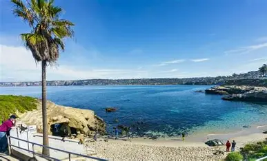 Open shoreline and rustic palapas at Playa San Diego with gentle surf and fresh seafood stands.