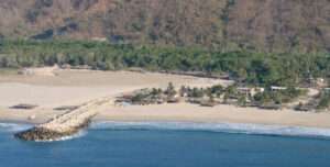 Cliffside view of Playa Cerro Hermoso with golden sands and panoramic Pacific horizon near Chacahua