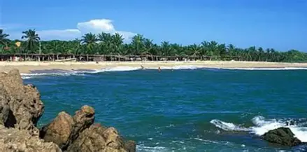 “Expansive shoreline at Marquelia Beach with warm Pacific waters, rustic palapas, and a tranquil Costa Chica backdrop.”