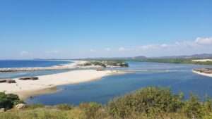 Expansive lagoon and beach at Playa Corralero, Oaxaca, known for bird sanctuaries and ancestral fishing