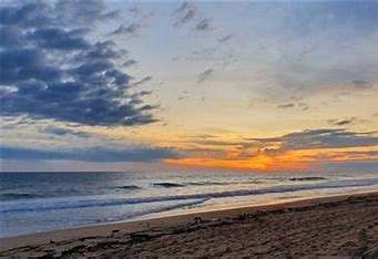 “Tranquil shoreline at Pie de la Cuesta Beach with golden sand, gentle waves, and sunset hues over the Pacific—ideal for nature retreats and lagoon-side escapes near Acapulco.”